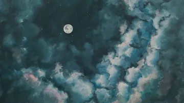 Moon shining in a cloudy night sky.