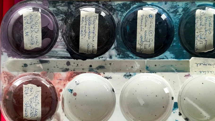 Farbpalette mit beschrifteten Gläsern, gemischte Farben.