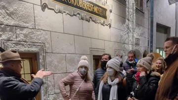 Führer spricht mit Touristen vor dem Oktoberfest-Museum.