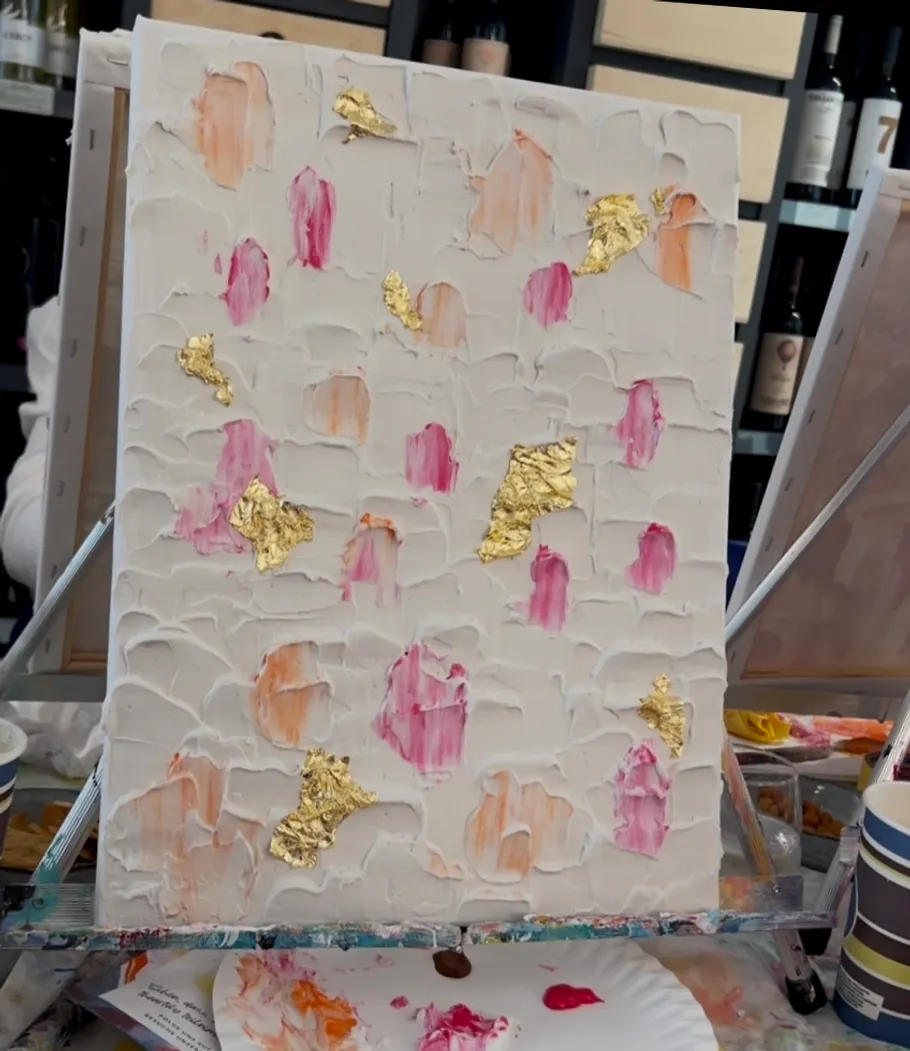 Textured abstract painting with gold and pink.