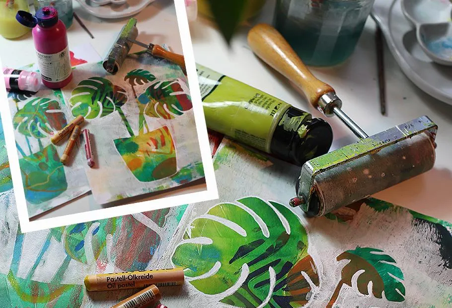 Art tools and printed leaves on a table.