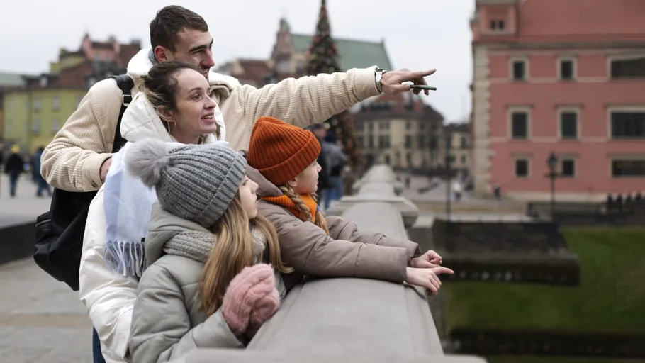 Familie zeigt und schaut über Stadtbrücke.