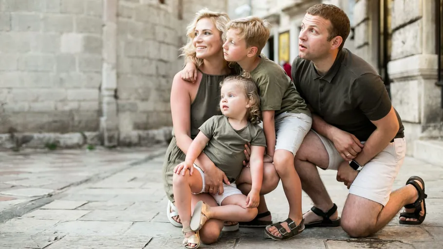 Family posing happily on a cobblestone street.