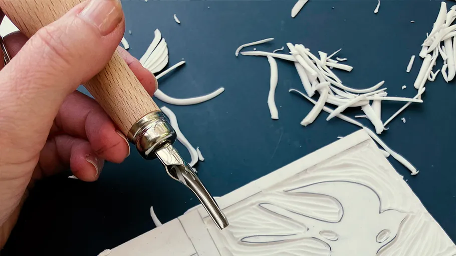 Hand carving design into linoleum sheet.