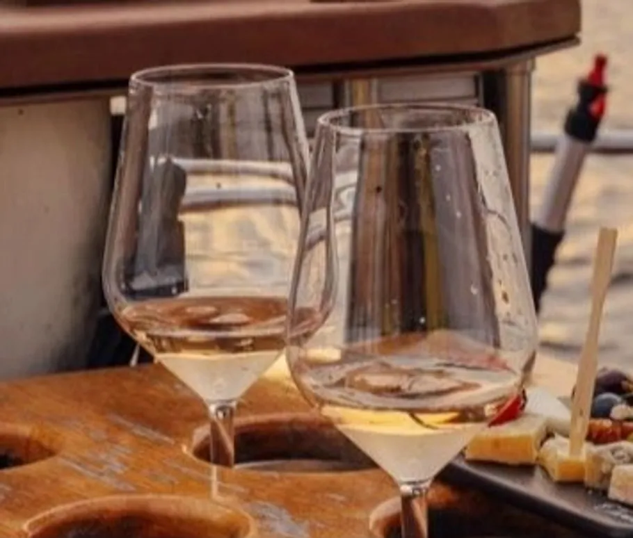 Wine glasses on table with cheese platter.