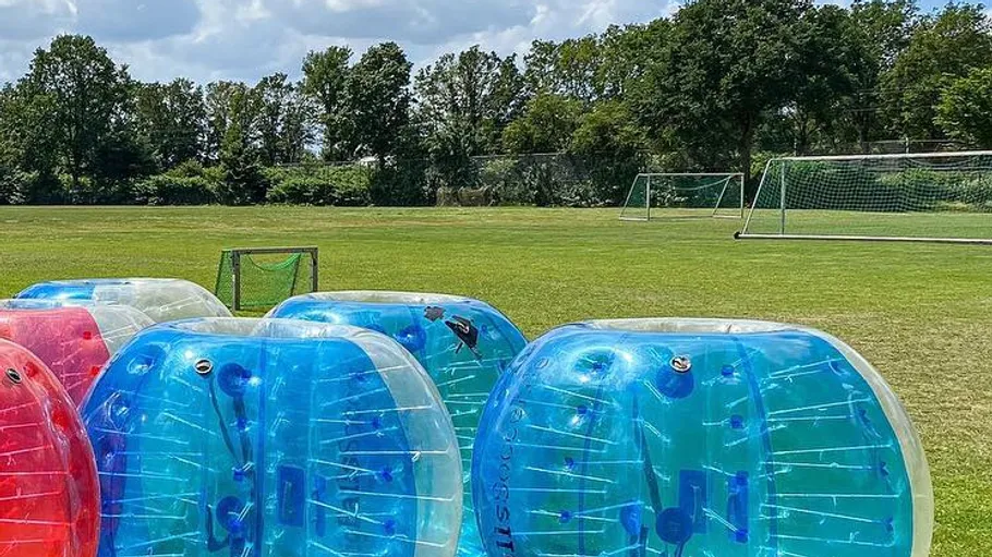 Inflatable bubbles on grass near soccer goals.