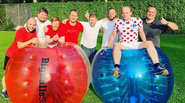 Gruppe von Männern mit Bubbleballs auf Rasen.