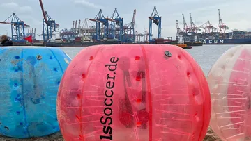 Aufblasbare Bälle am Strand nahe Hafen.
