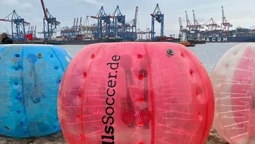 Bunte Bubble-Bälle an einem Hafenstrand.