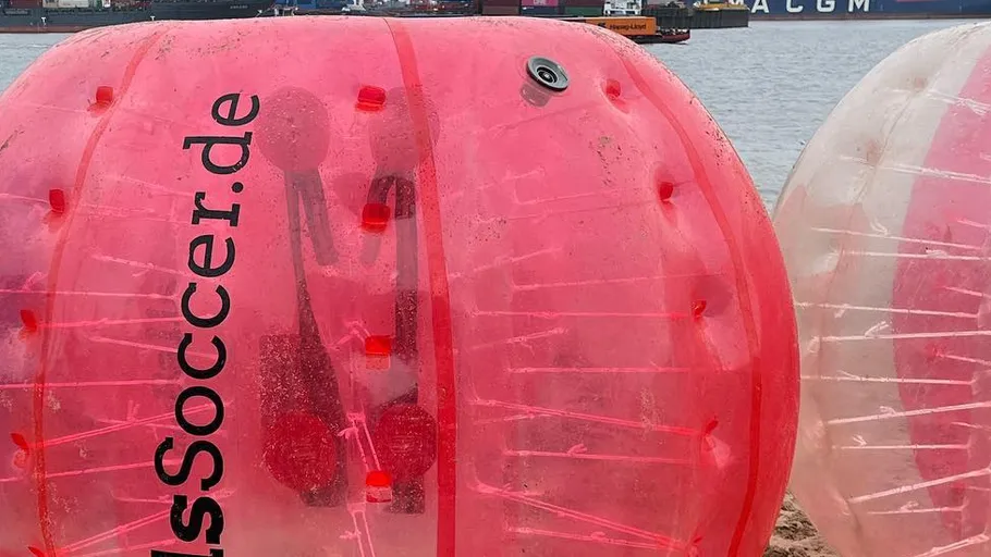 Inflatable bubble on beach near water.