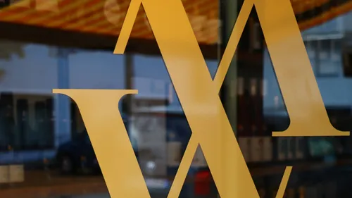 Gelbes Logo auf Glasfenster-Hintergrund.