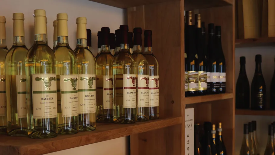 Wine bottles displayed on wooden shelves.