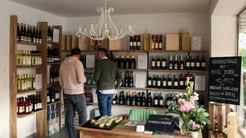 Zwei Männer betrachten Wein in einem Geschäft.