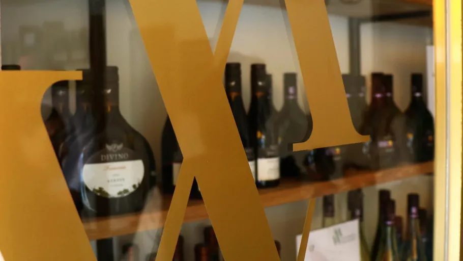 Weinflaschen durch große goldene Buchstaben sichtbar.