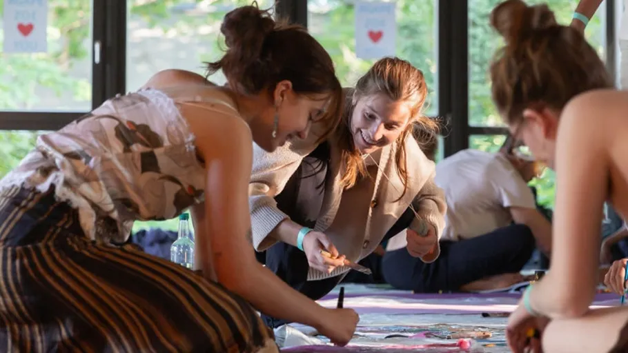 People crafting on a floor in a sunny room.