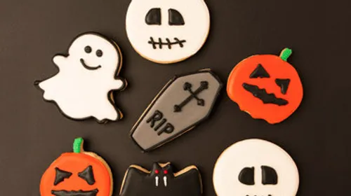 Halloween-themed cookies on a black background.