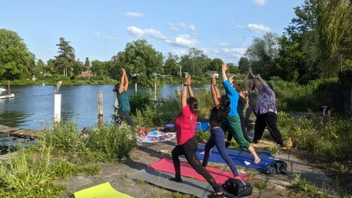 Group practicing yoga by a riverside.