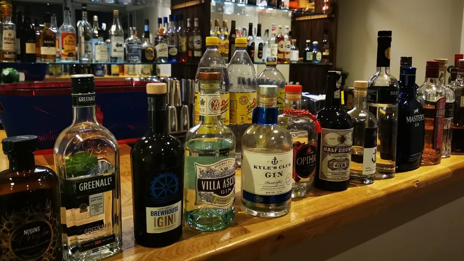 Verschiedene Spirituosenflaschen auf einer Bar aufgereiht.