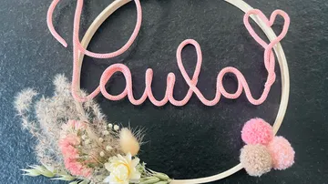 Decorative hoop with pink wire name and flowers.