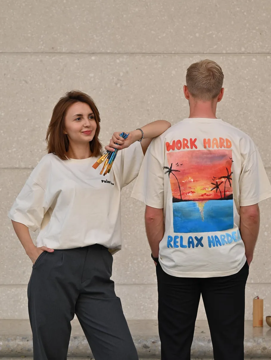Zwei Personen in T-Shirts stehen draußen.