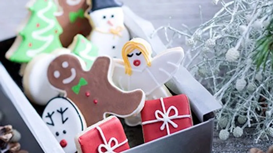 Weihnachtsplätzchen in einer festlichen Schachtel mit Dekorationen.