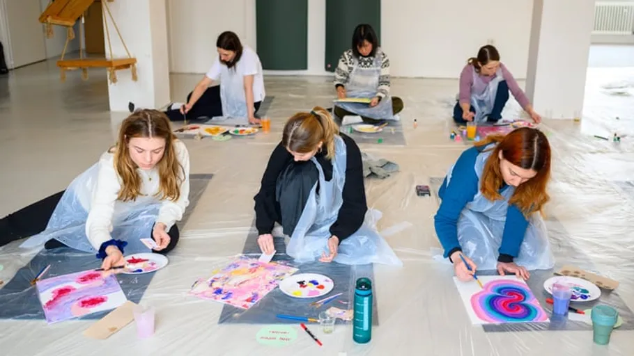 Gruppe malt auf dem Boden im Kunstworkshop.