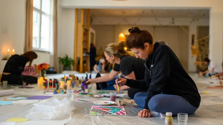 Menschen malen auf dem Boden in einem Studio.