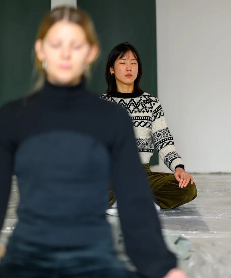 Two people meditating in a quiet room.
