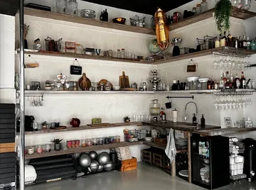 Rustic kitchen shelf with various kitchen items.