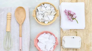 Kitchen utensils and paper scraps on table.