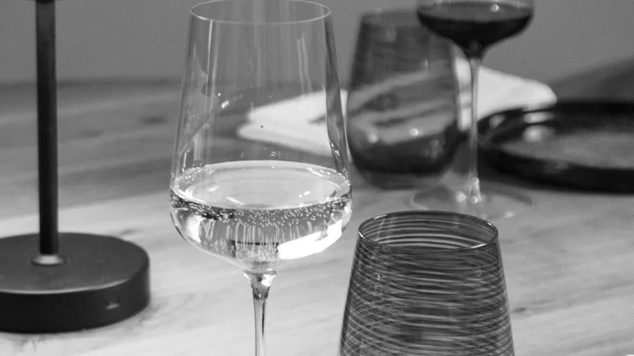 Wine glasses and cups on a wooden table.