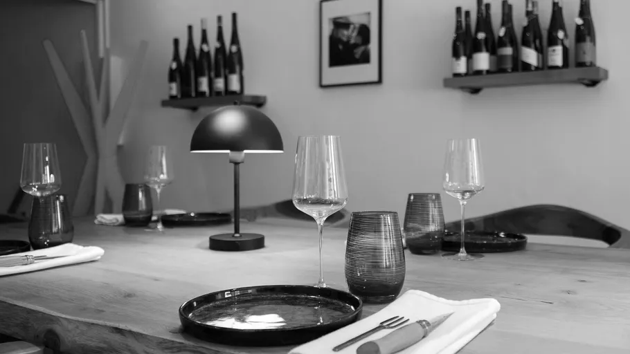 Dining table set with wine glasses and plates.