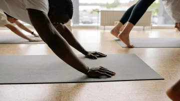 People practicing yoga on mats in a studio.