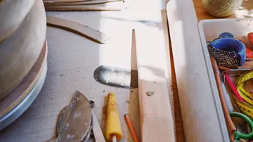 Töpferwerkzeuge auf einem Holztisch.