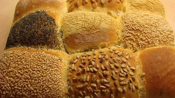 Assorted bread rolls with various seed toppings.