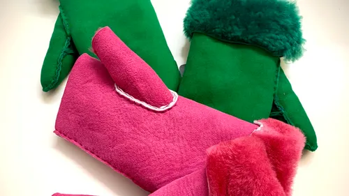 Pink and green mittens on white background.