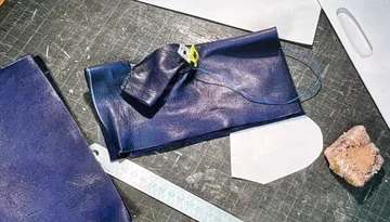 Leather pieces, measuring tape on crafting table.