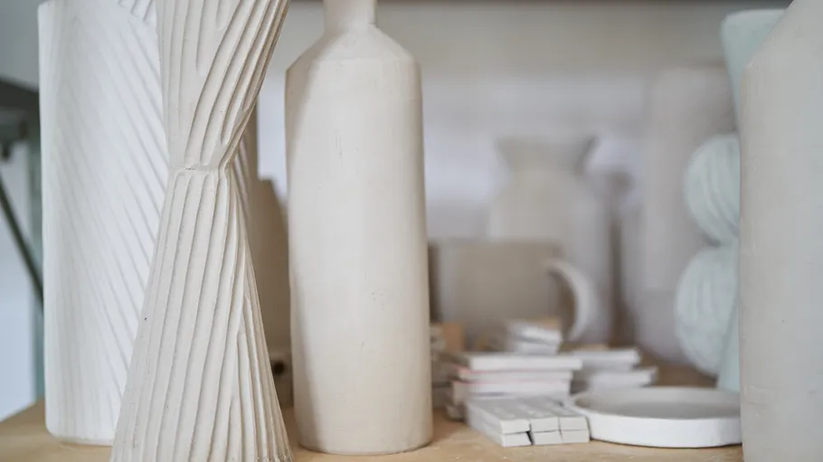 White ceramic vases displayed on a shelf.