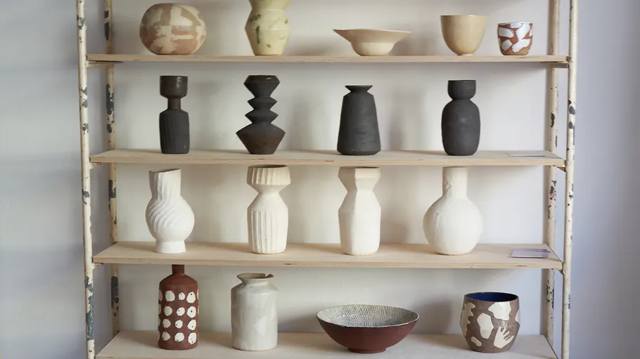 Ceramic vases and bowls on a wooden shelf.