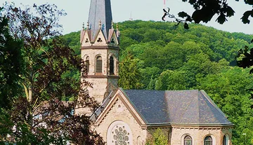 Church with steeple surrounded by trees.