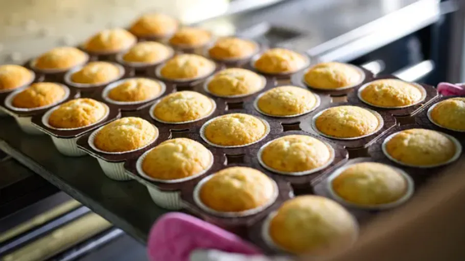 Frisch gebackene Muffins auf einem Backblech.