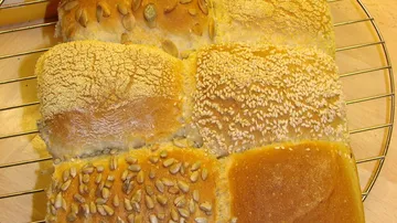 Verschiedene Brötchen auf einem Abkühlgitter.
