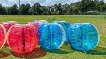 Inflatable balls arranged on a grassy field.
