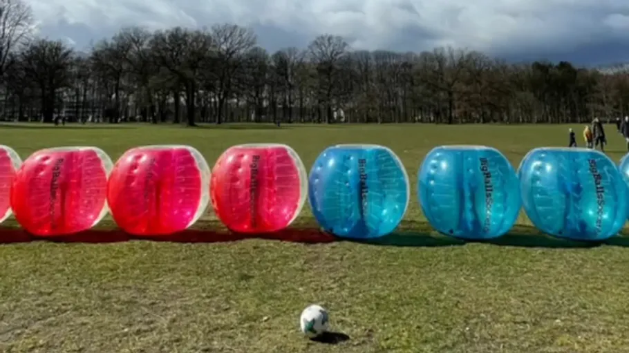 Inflatable bumper balls on a grassy field.