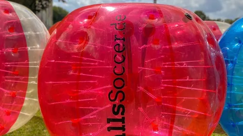Colorful inflatable ball on grassy field.
