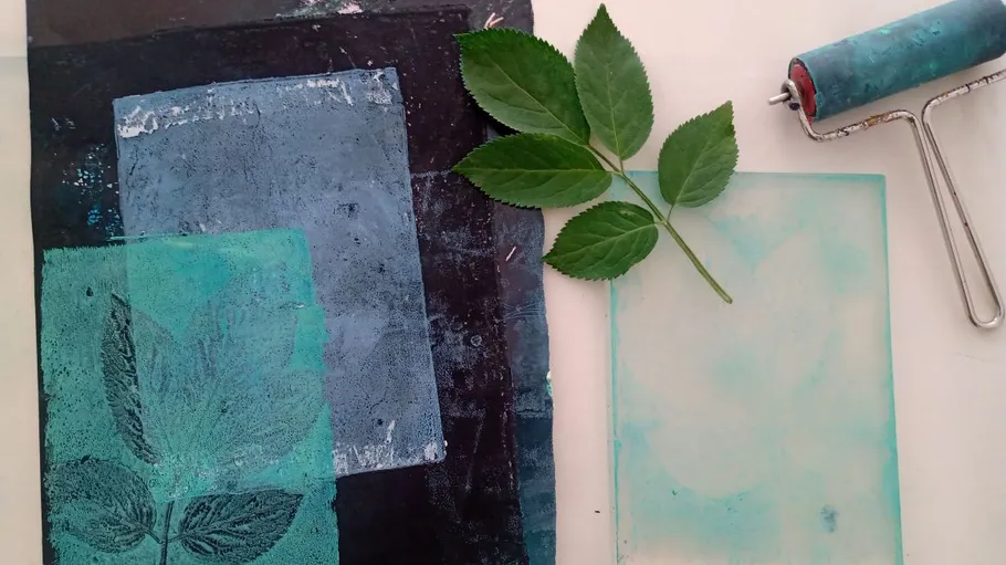 Blatt mit Kunstdrucken und Rolle auf Tisch.