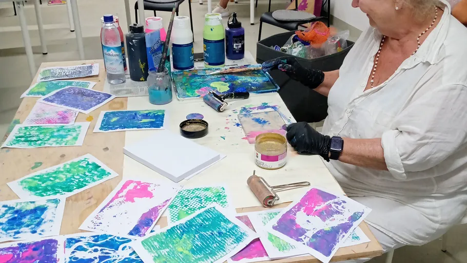 Frau erstellt bunte abstrakte Kunst am Tisch.