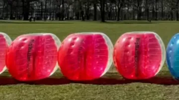 Aufblasbare Bälle auf Rasen angeordnet.