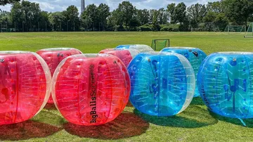 Inflatable balls on grass field for bubble soccer.