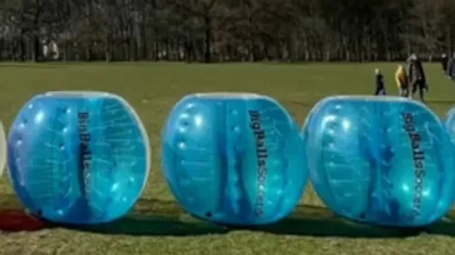 Blue bubble balls on a grassy field.